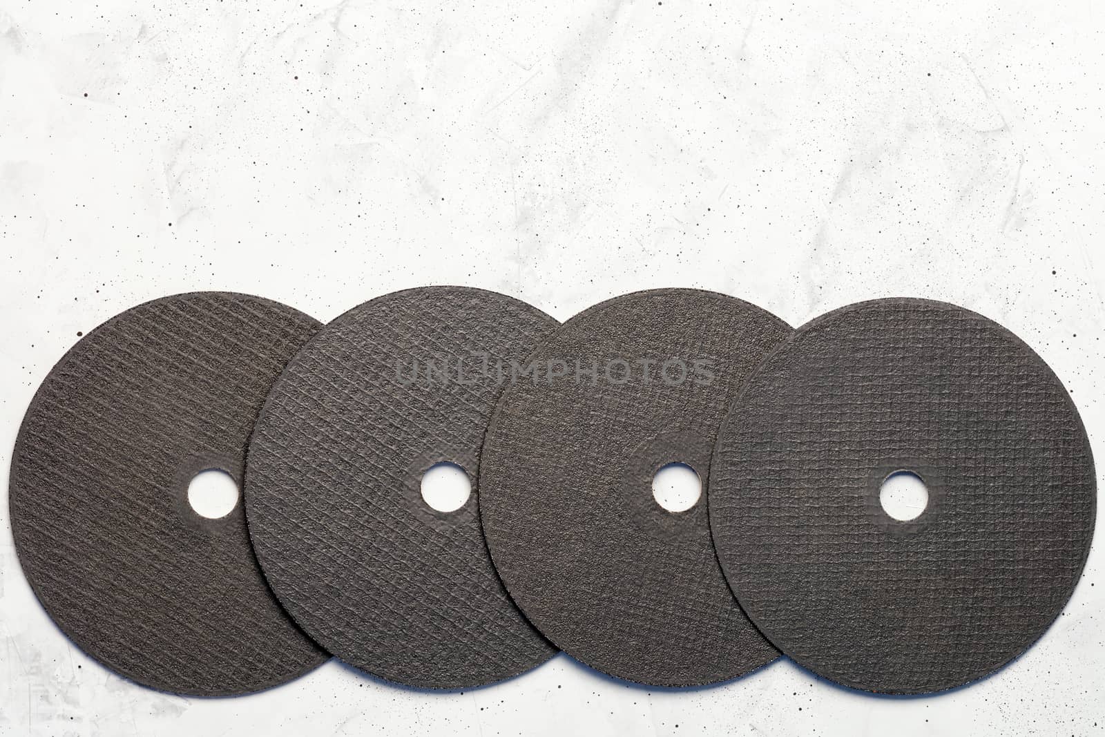 Set of cutting abrasive disc for cutting of the metal on the gray concrete close-up, image with copy space.