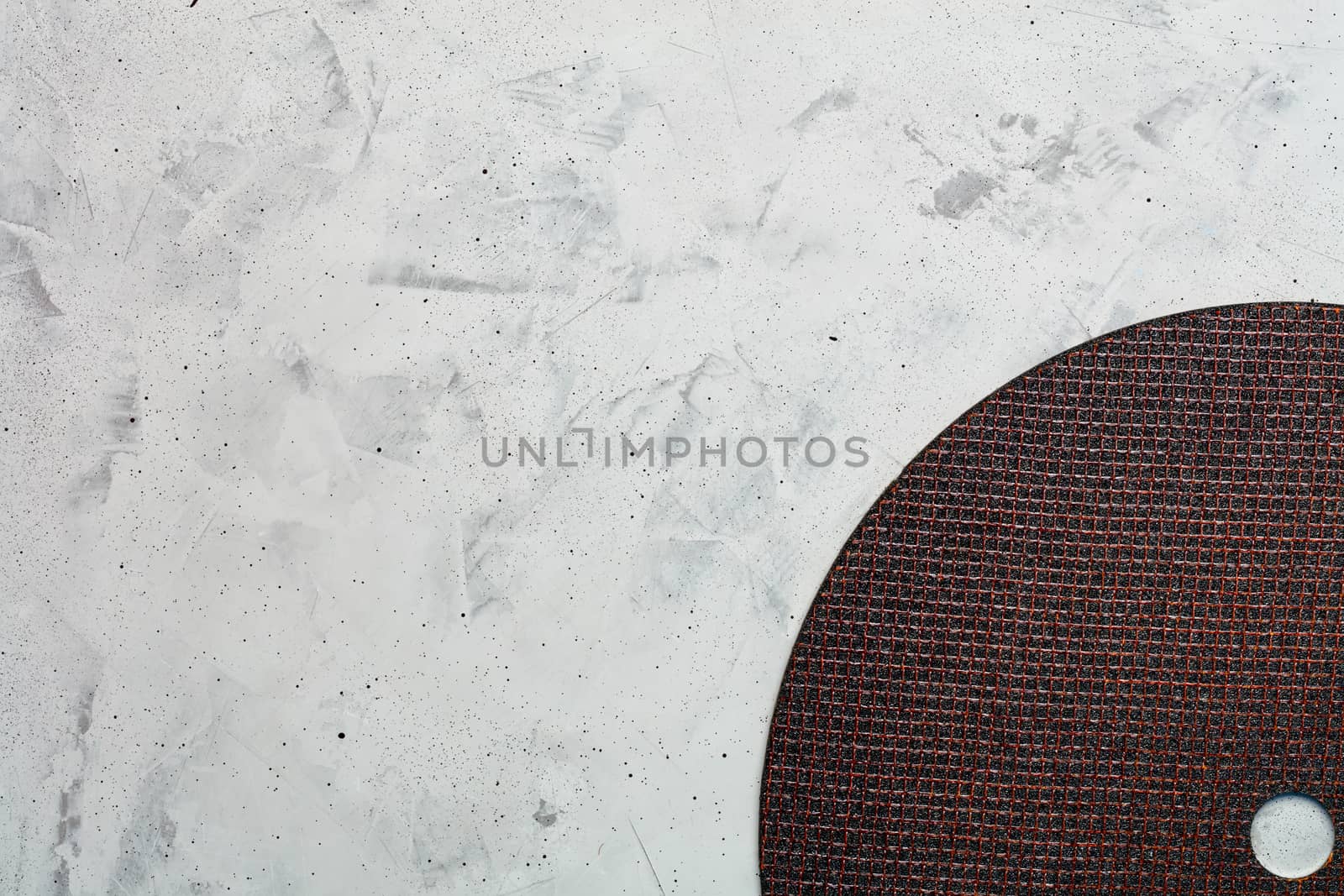 Segment of a diamond blue cutting disc on a background of gray concrete close-up, image with copy space.