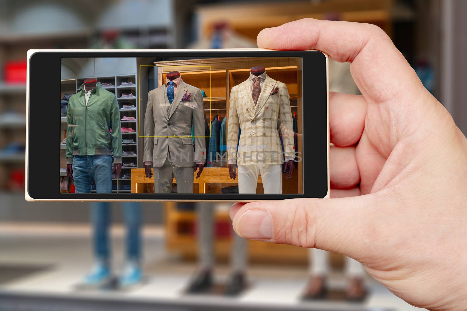 Male mannequin on smartphone screen. Sale of mens clothing. Showcase clothing store.