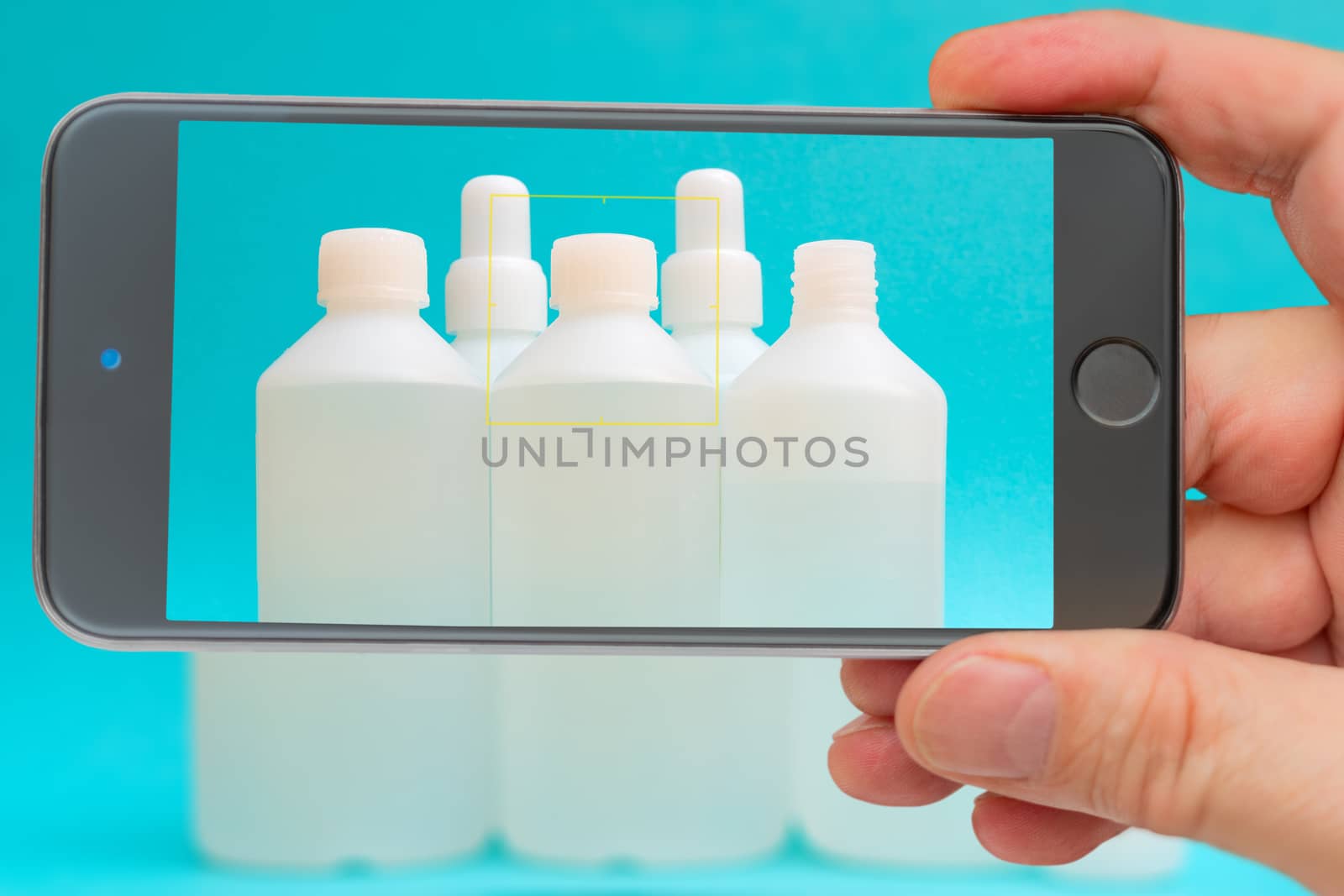 Antiseptic vials on smartphone screen. Disinfectant liquid in a white bottle. Therapeutic drug. Disinfection against coronavirus.