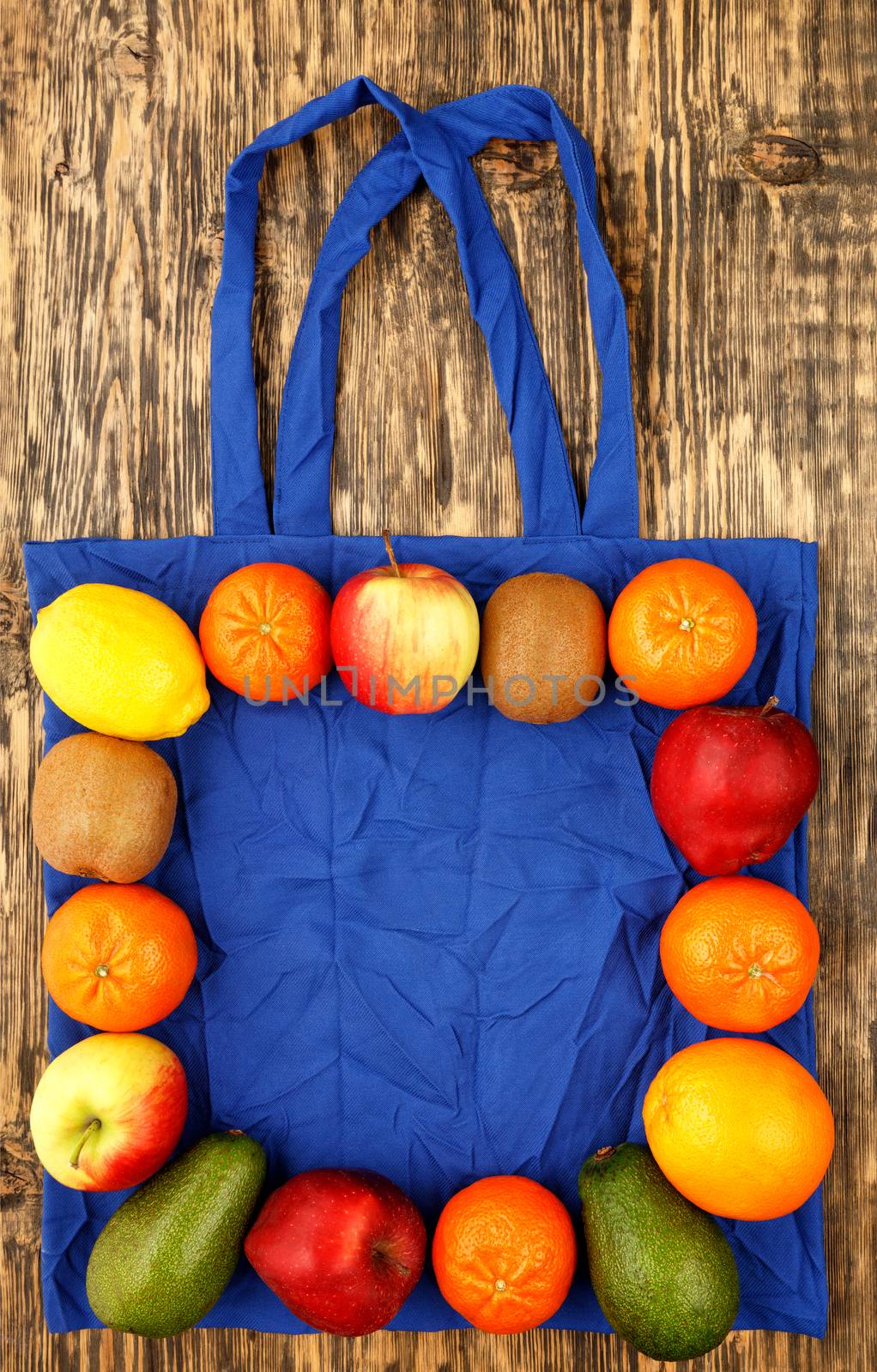 Eco-friendly cotton bag in blue color against a wooden background. Zero waste concept, plastic-free, eco-friendly shopping with fruits, image with copy space.