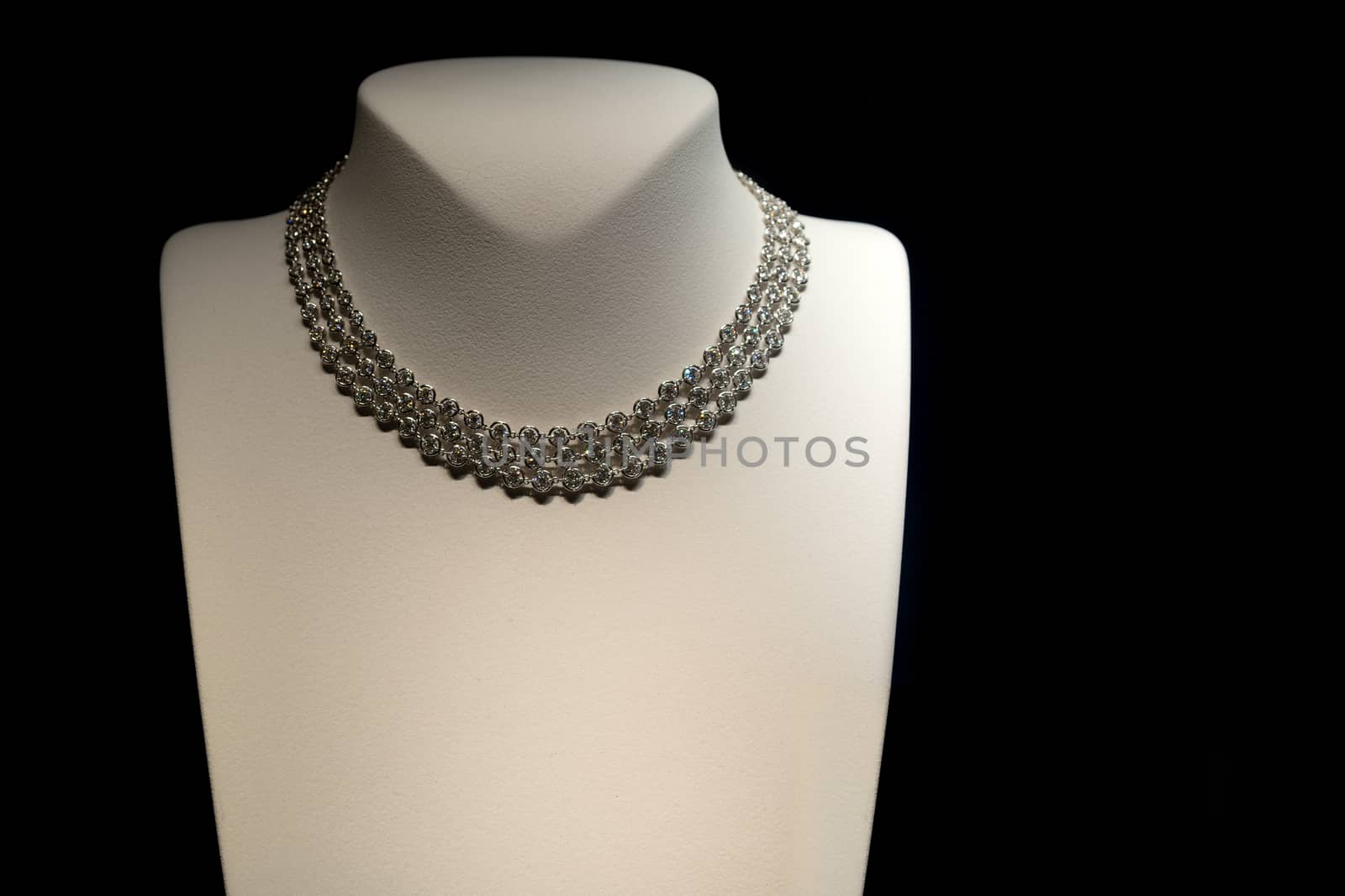 Female beautiful necklace on mannequin. Showcase jewelry store.