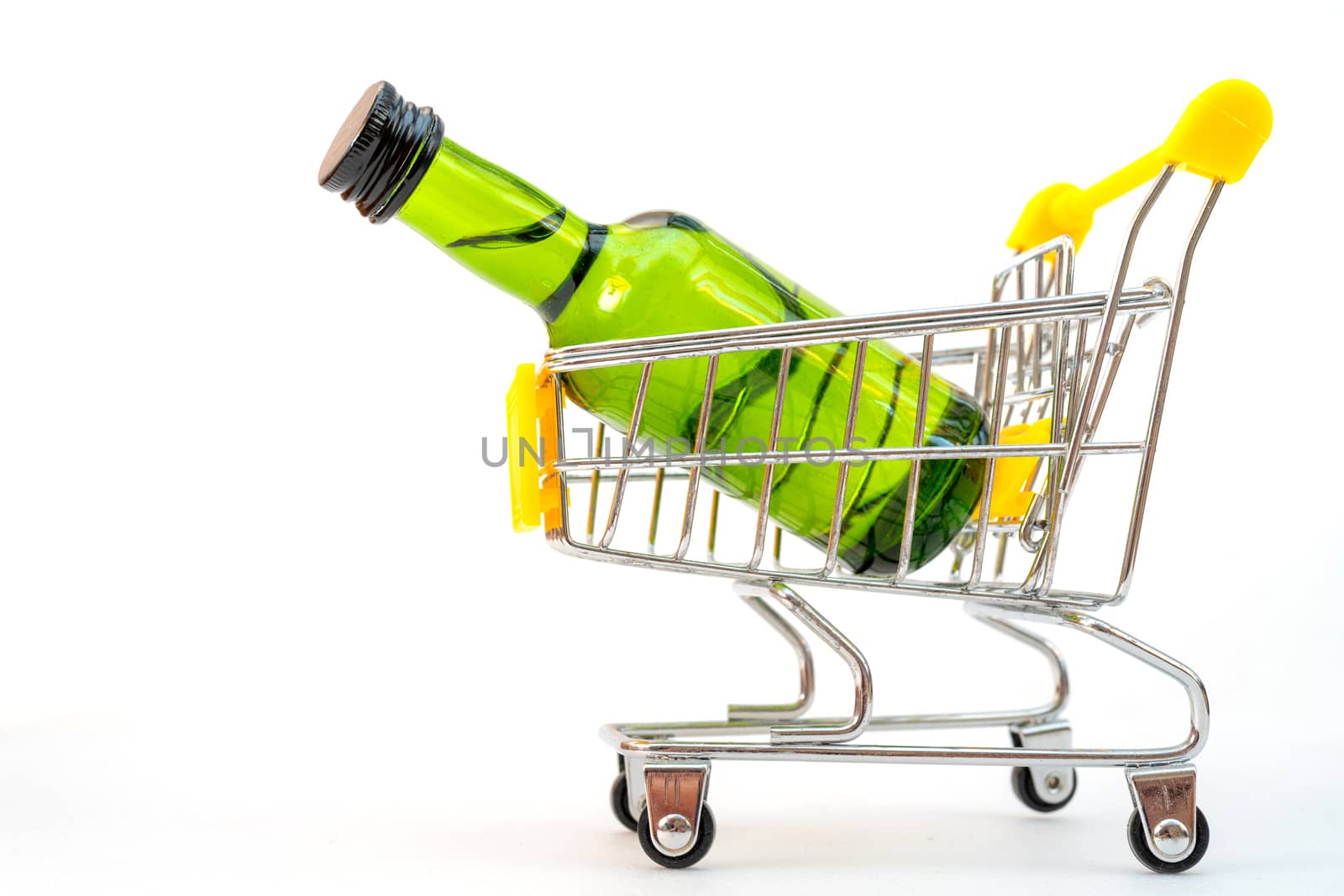 Selling alcohol in a store. Green bottle in a supermarket cart. Drink in a green bottle.