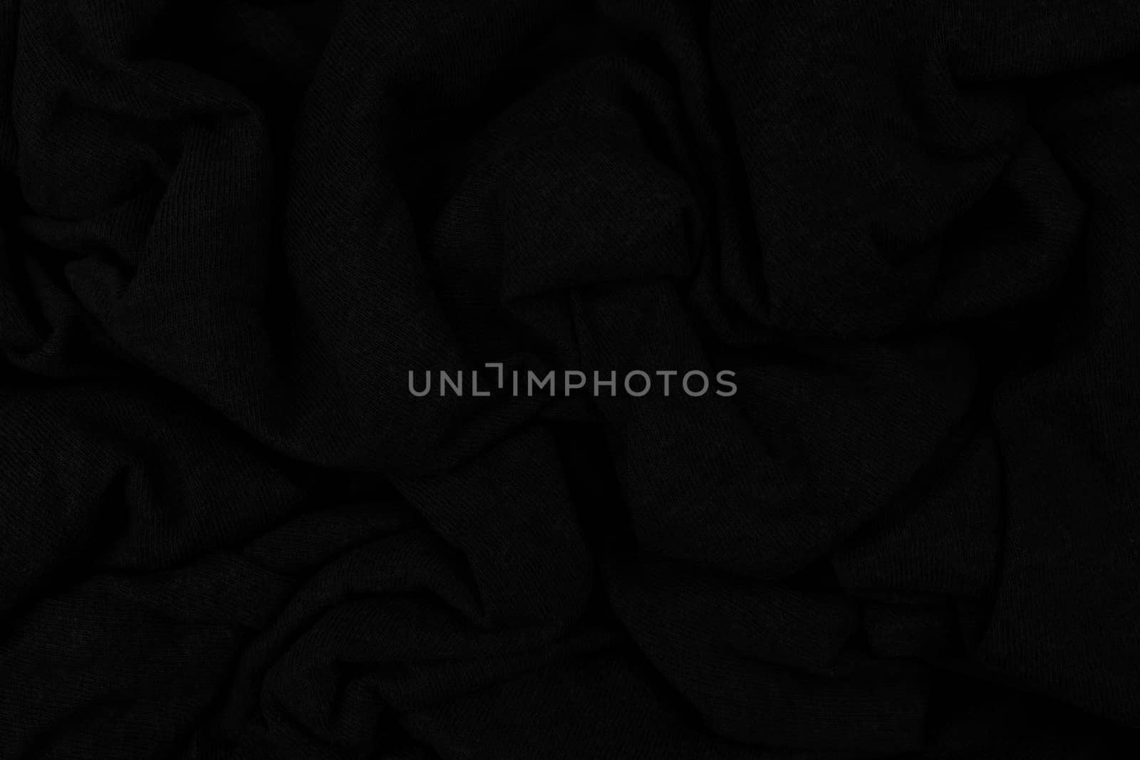 Folds of crumpled wool. Textile product. Abstract dark background.