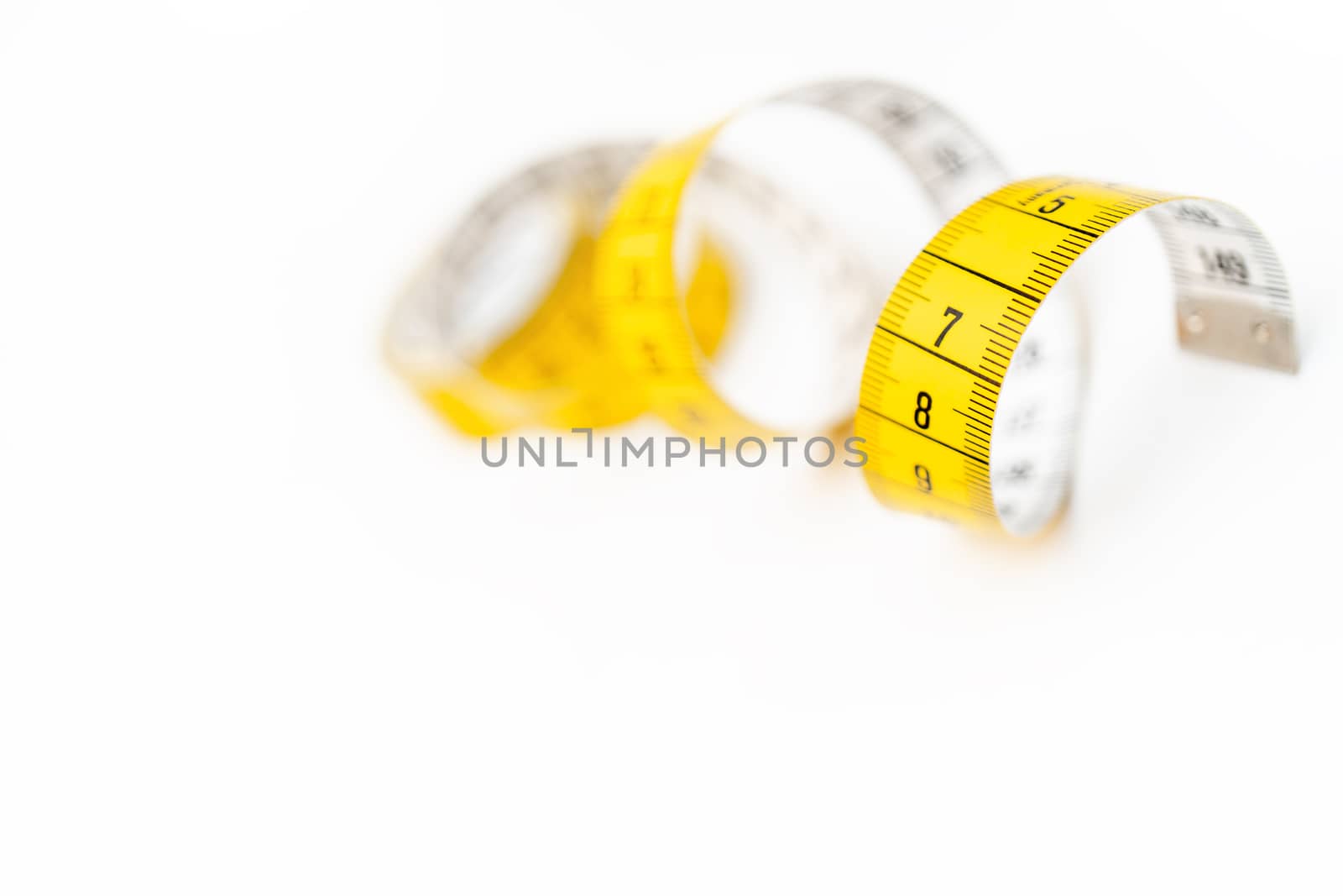 Yellow measuring tape on white background. Measurement of length and circumference. Lose weight and get fat.