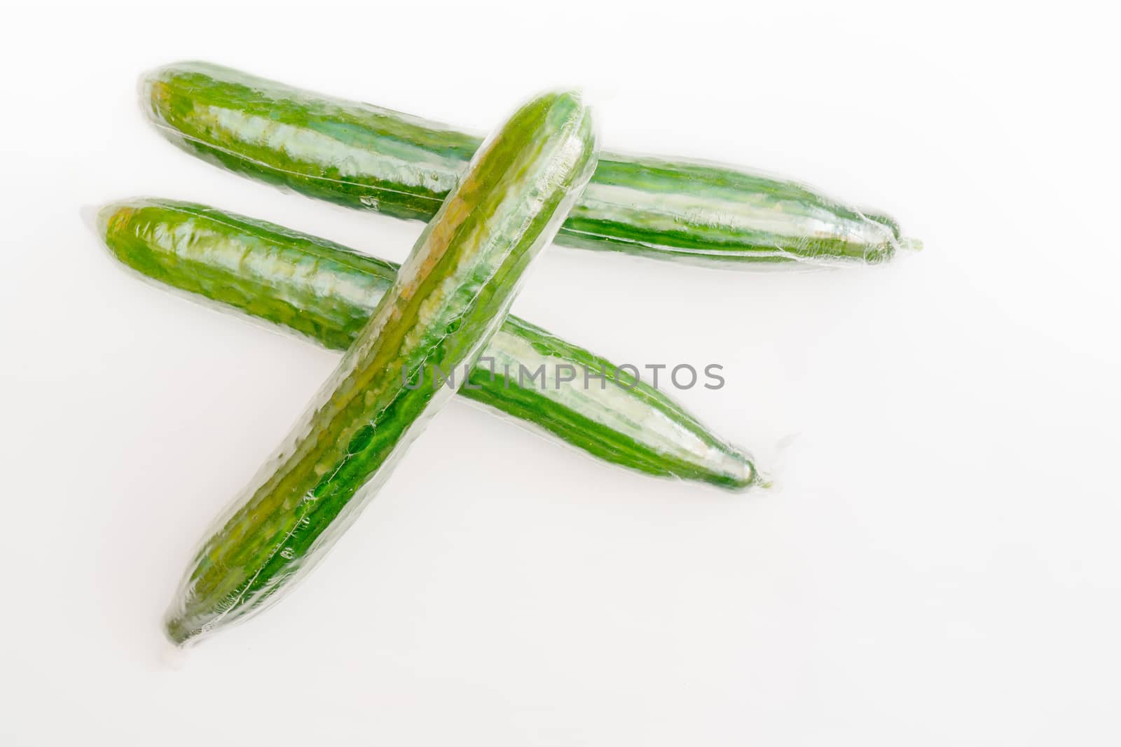 Ripe green long cucumbers. Vegetables on white background.