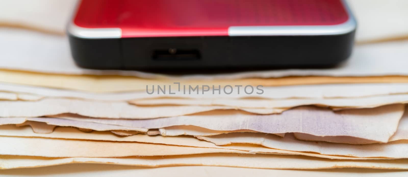 Hard drive for storing information. Stack of vintage paper. Old yellow sheets of paper. Yellow pages of the book.