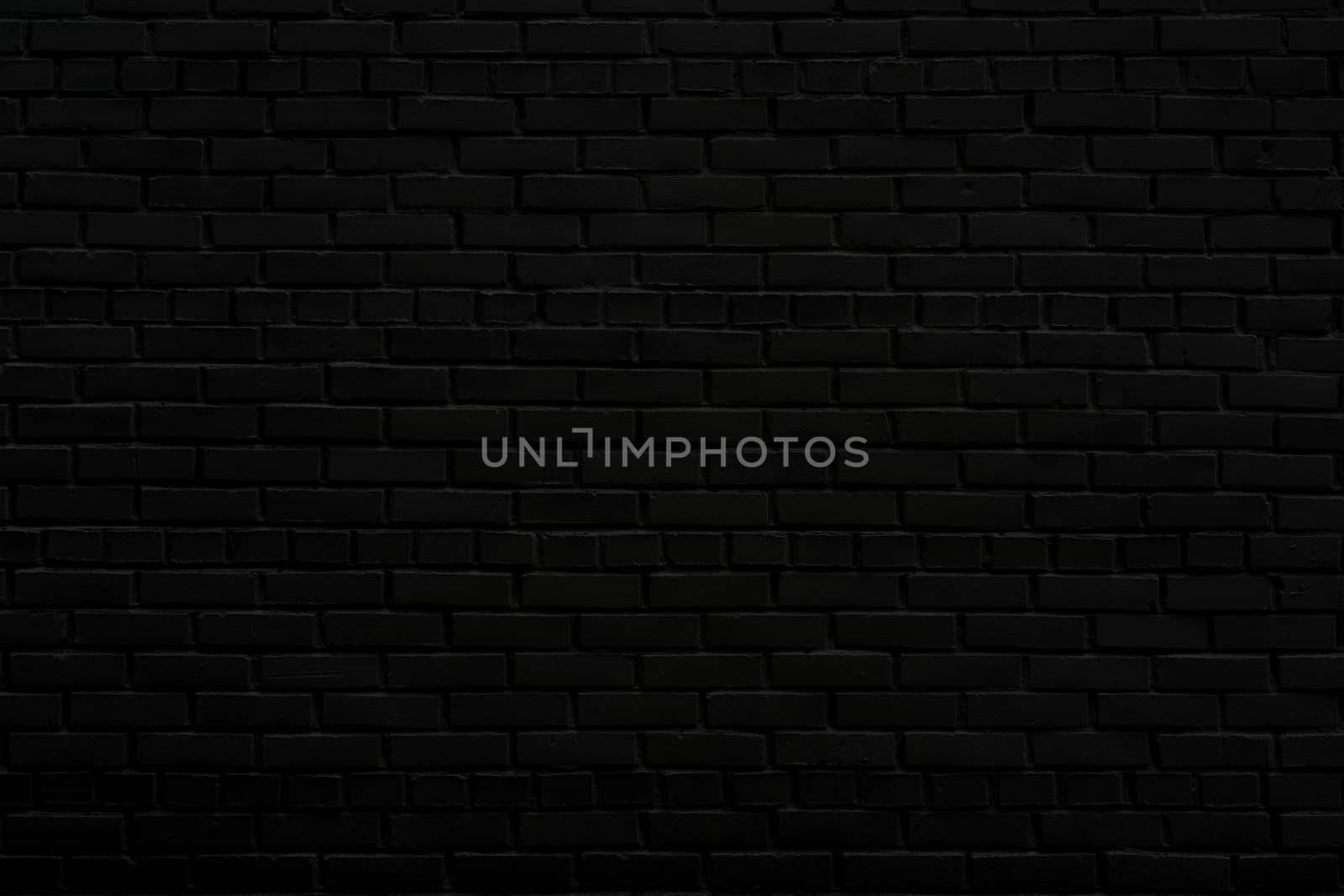 The black wall of the house. Old brick wall. Black paint on a brick wall.
