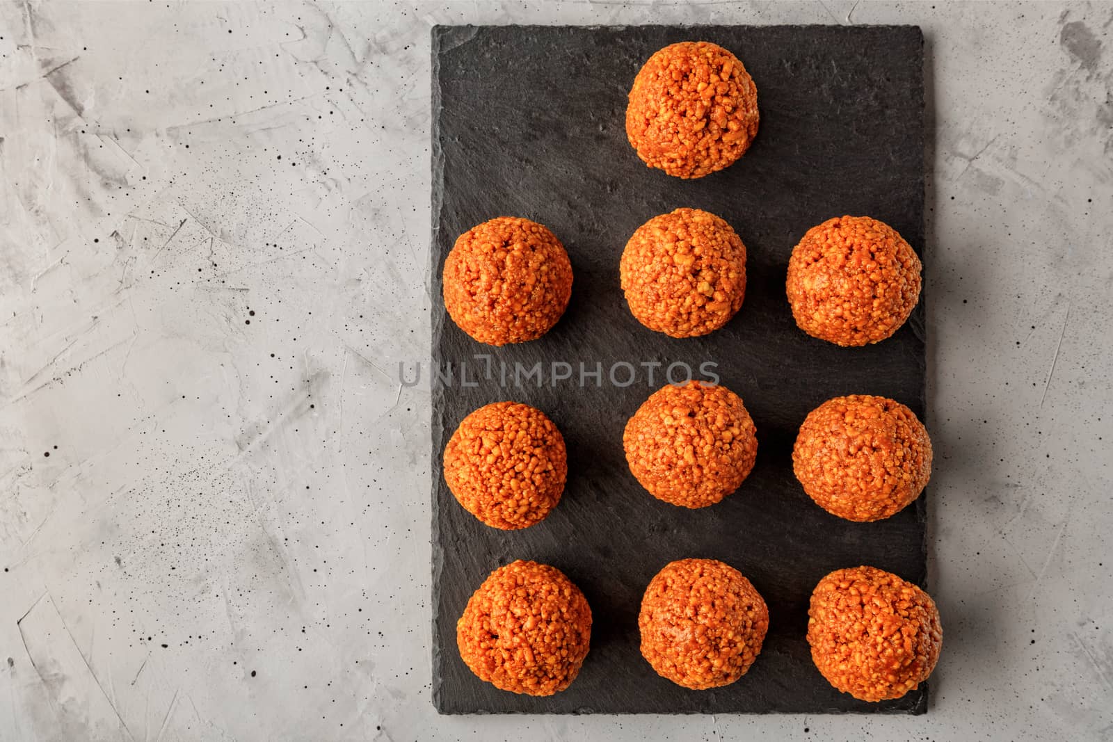 Homemade energy balls with walnuts, peanut, honey and banana on a gray concrete background. Vegan Vegetarian Raw Snacks. Healthy Sweet Food. Copy space. Flat lay, top view.