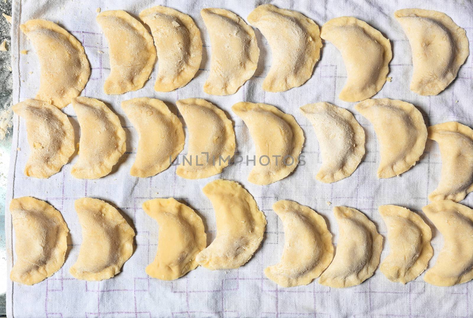 Raw dumplings laid on a tissue napkin for subsequent cooking. Ukrainian national cuisine, flat lay.