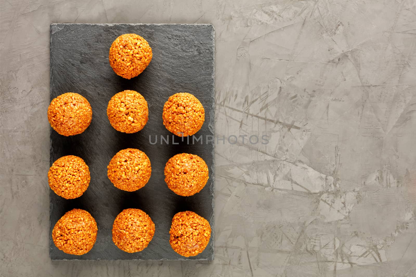 Homemade energy balls with walnuts, peanut, honey and banana on a brown concrete background. Vegan Vegetarian Raw Snacks. Healthy Sweet Food. Copy space. Flat lay, top view.