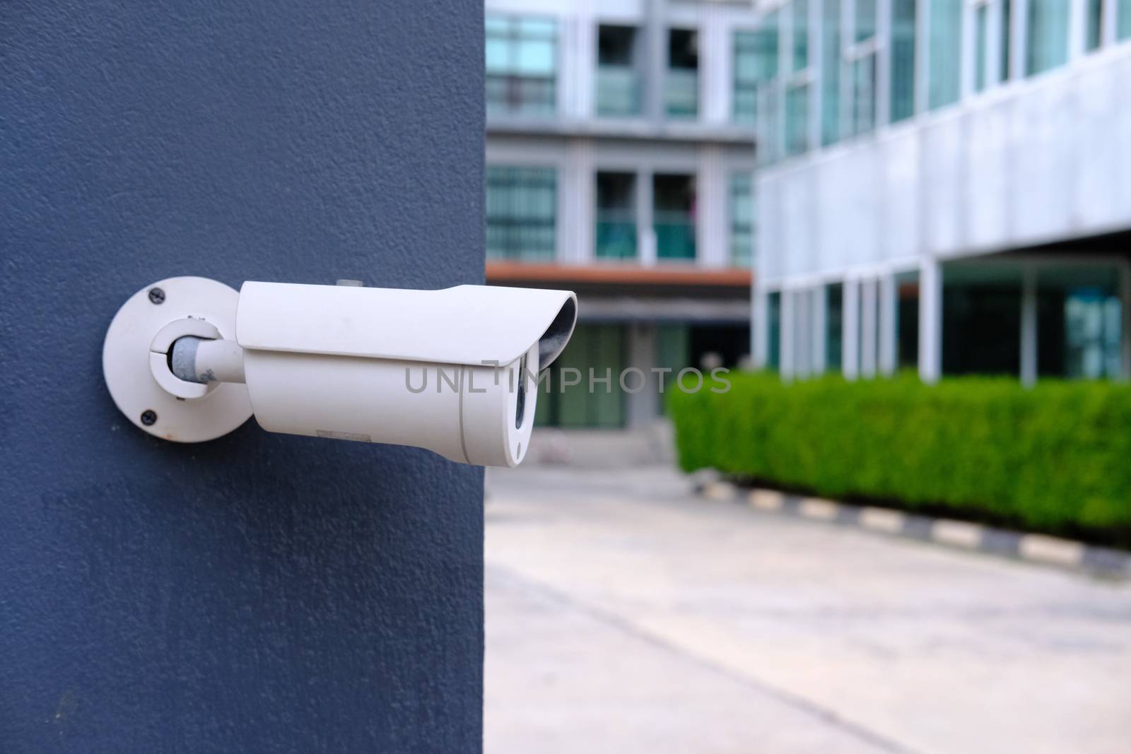 Closeup of CCTV camera on a wall. Video camera security system with house in background. 