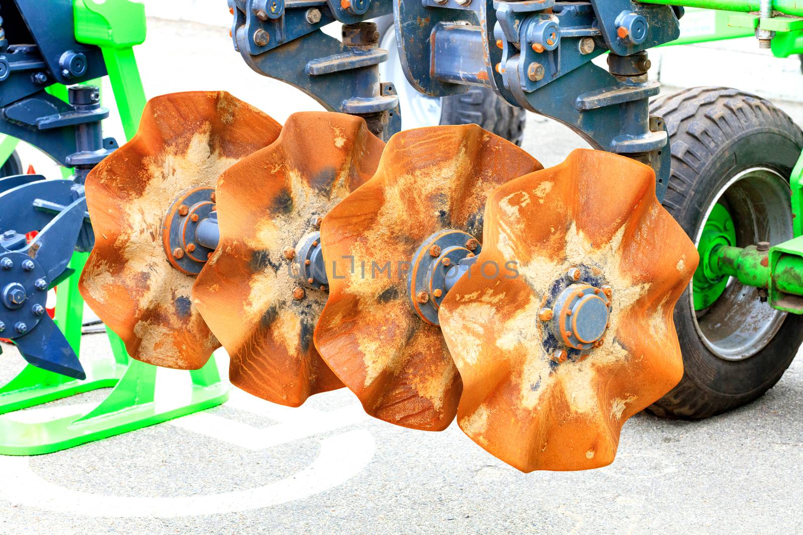 Metal disc harrow as a towing device for a tractor for tillage in the field, close-up.