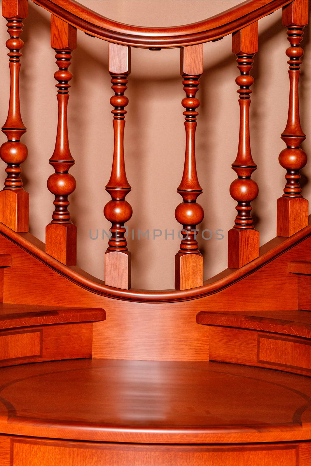 Fragment beautiful of a wooden staircase with figured carved balusters and railings and tinted mahogany.