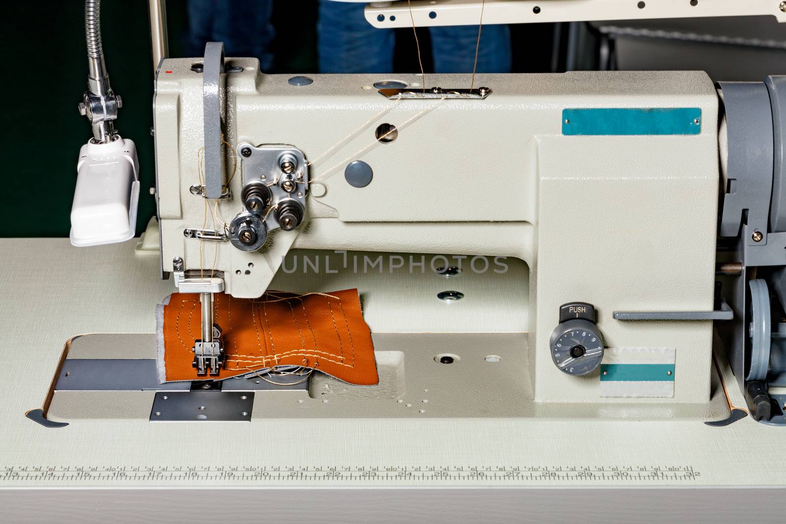 Modern machine for sewing furniture upholstery made of leather and various dense fabrics, the working part of the sewing machine close-up, copy space.