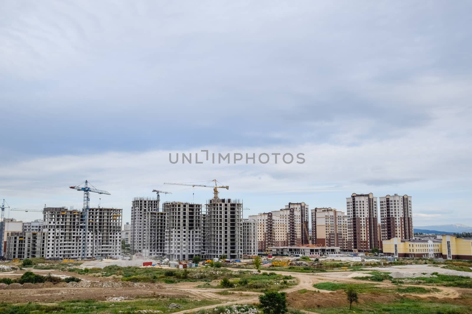 construction of multi-storey residential buildings. Tower cranes at a construction site. by fedoseevaolga