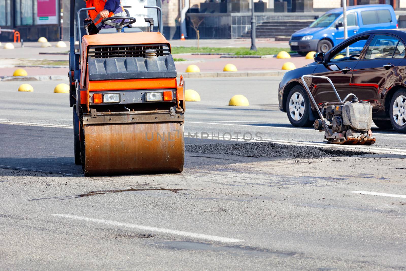 The road vibratory roller and rammer work on patching and updating the carriageway.