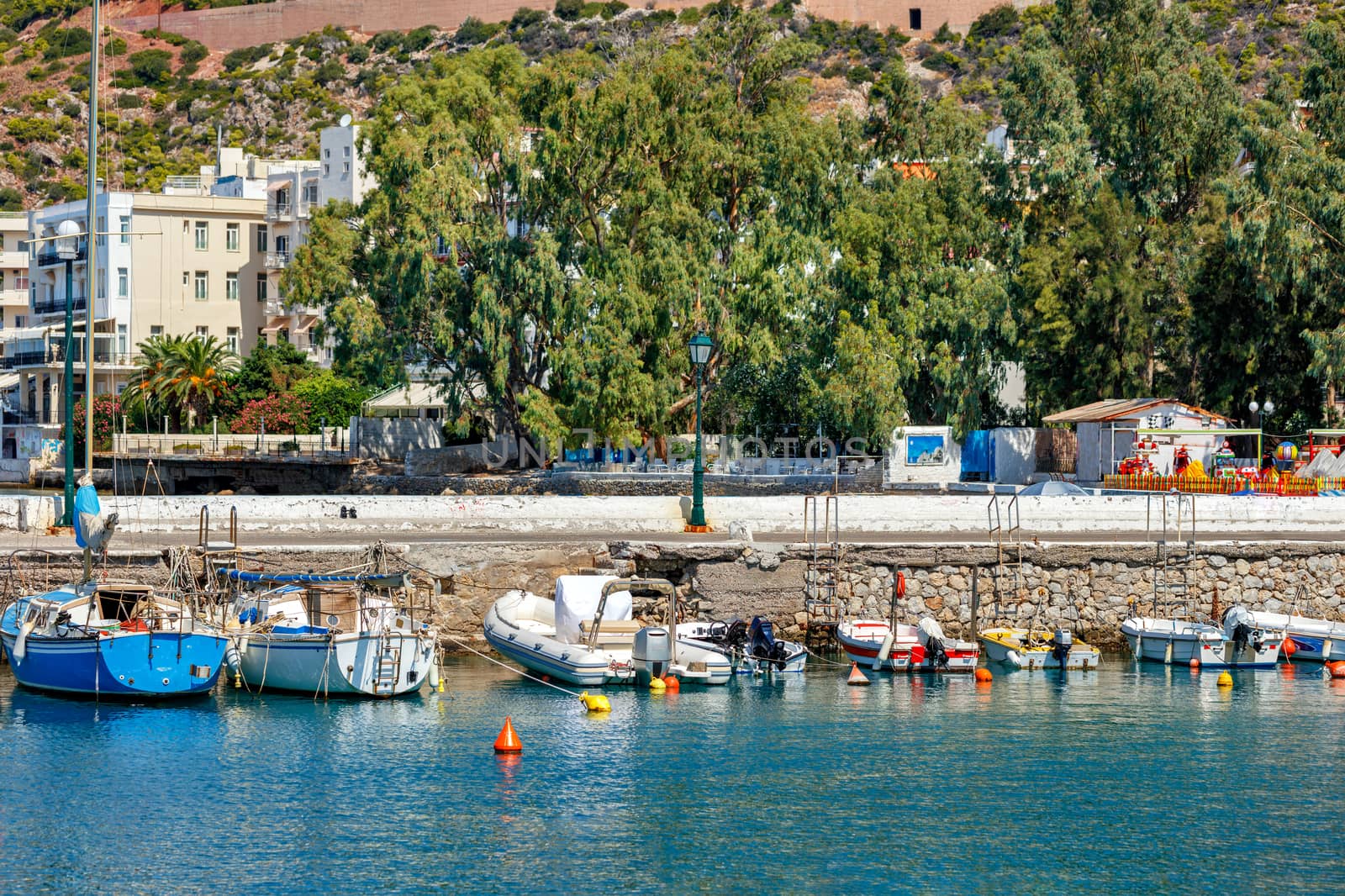 The picturesque promenade of Loutraki Bay, Greece, where old fishing schooners, boats and boats moor in the clear waters of the Ionian Sea. by Sergii