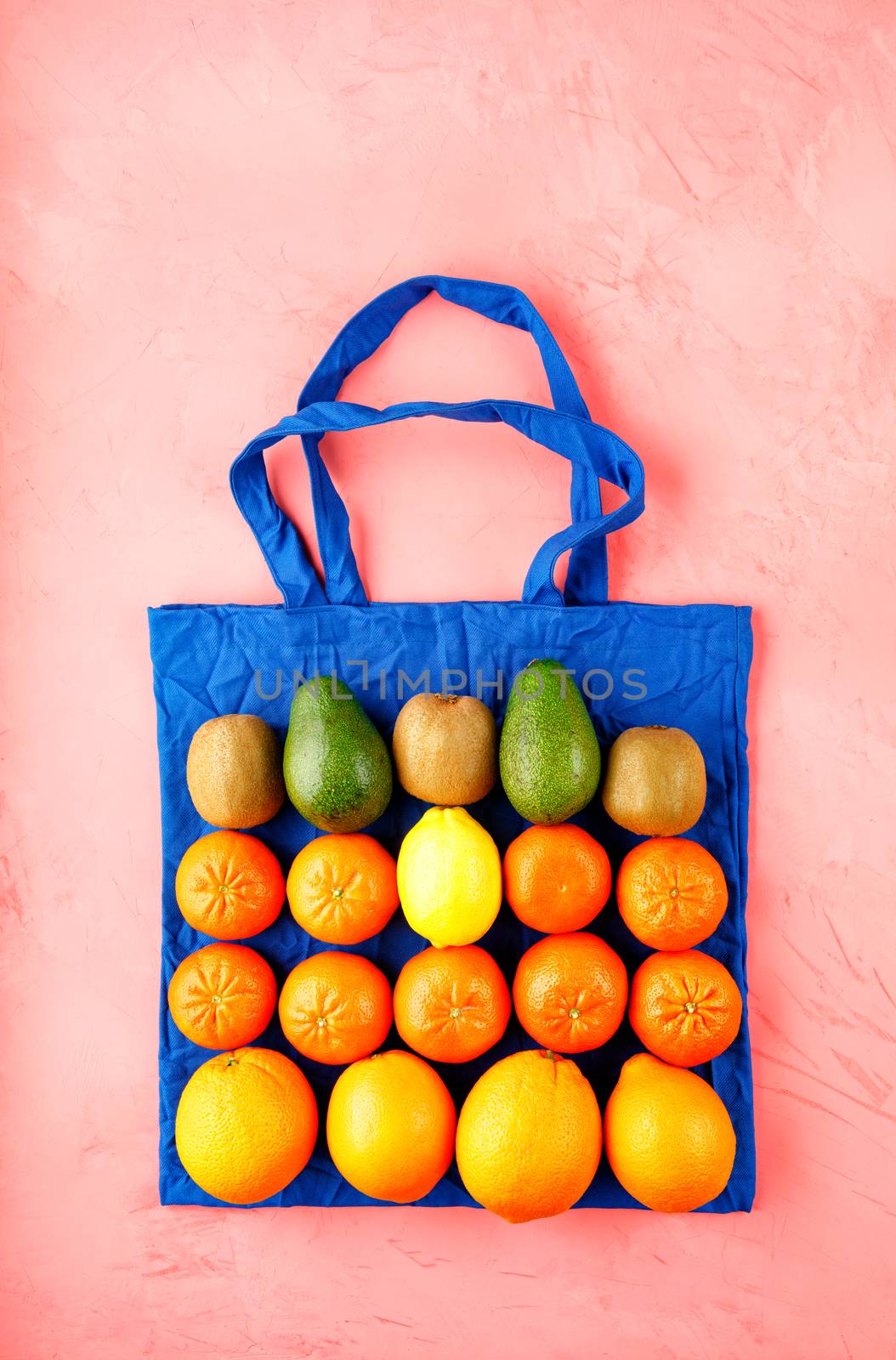 Zero waste concept, eco-friendly bag made of classic blue cotton on a pink background, no plastic, eco-friendly shops with fruits and vegetables, flat lay, copy space.