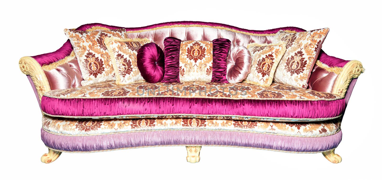 Soft beautiful sofa, upholstered in expensive brocade textile upholstery in pink shades, with many soft pillows, with curved carved legs, photographed in front, isolated on a white background.
