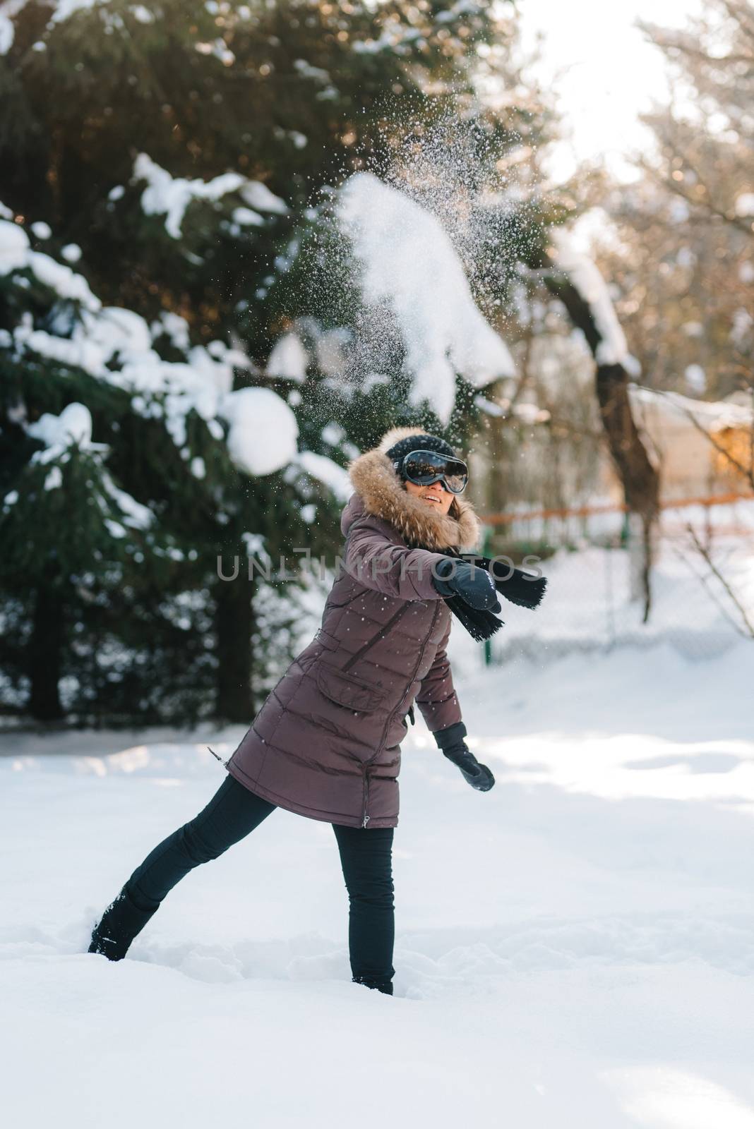 boy and girl outdoors on a winter walk playing snowballs and sledding