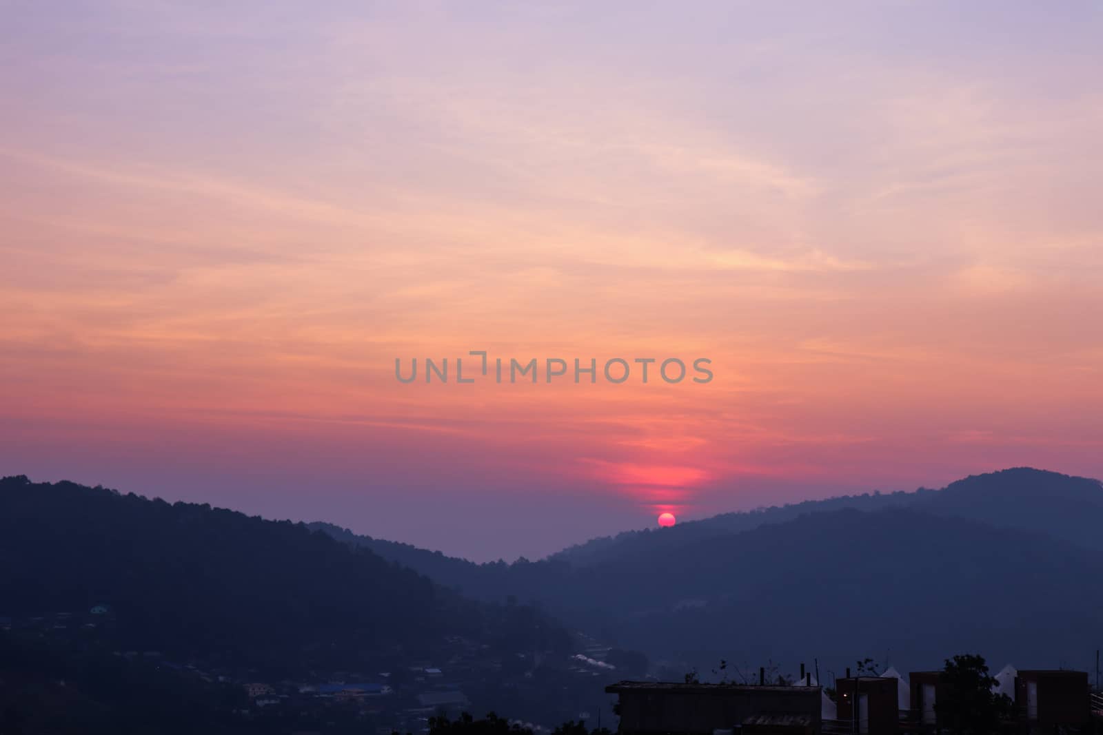 Sun setting over hills in a thai village near mountains in Chiang Mai, Thailand. The mountain scenery view