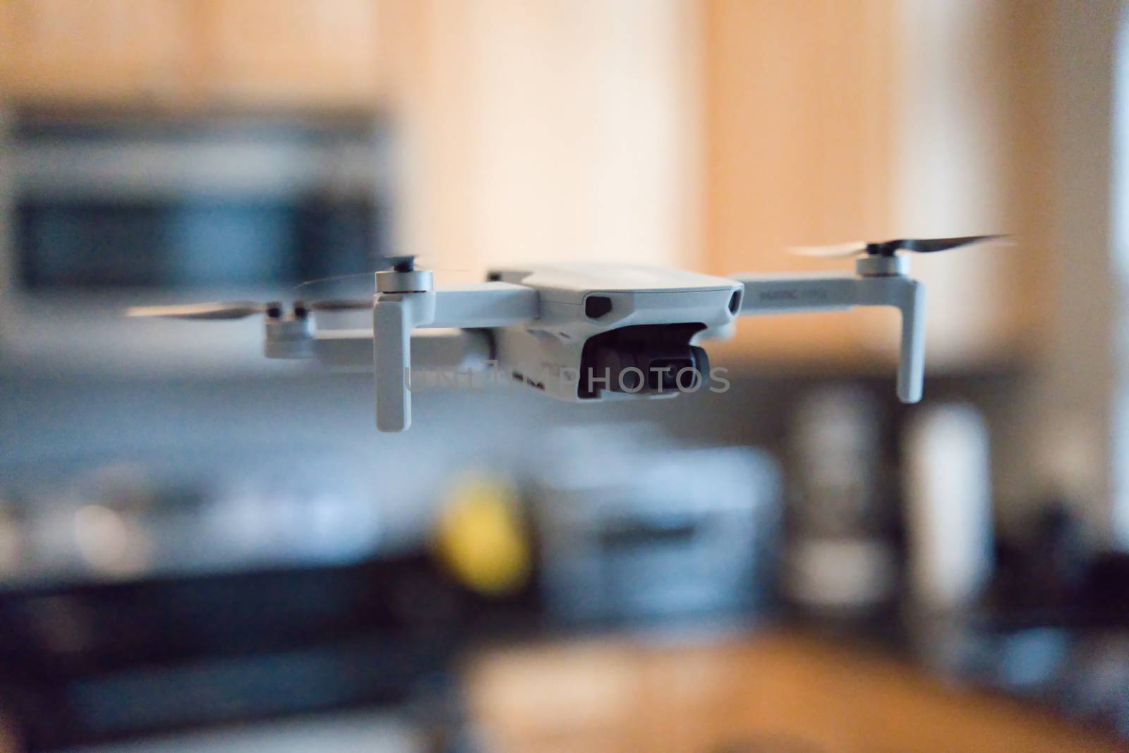 Drone flying indoors with kitchen visible in background.