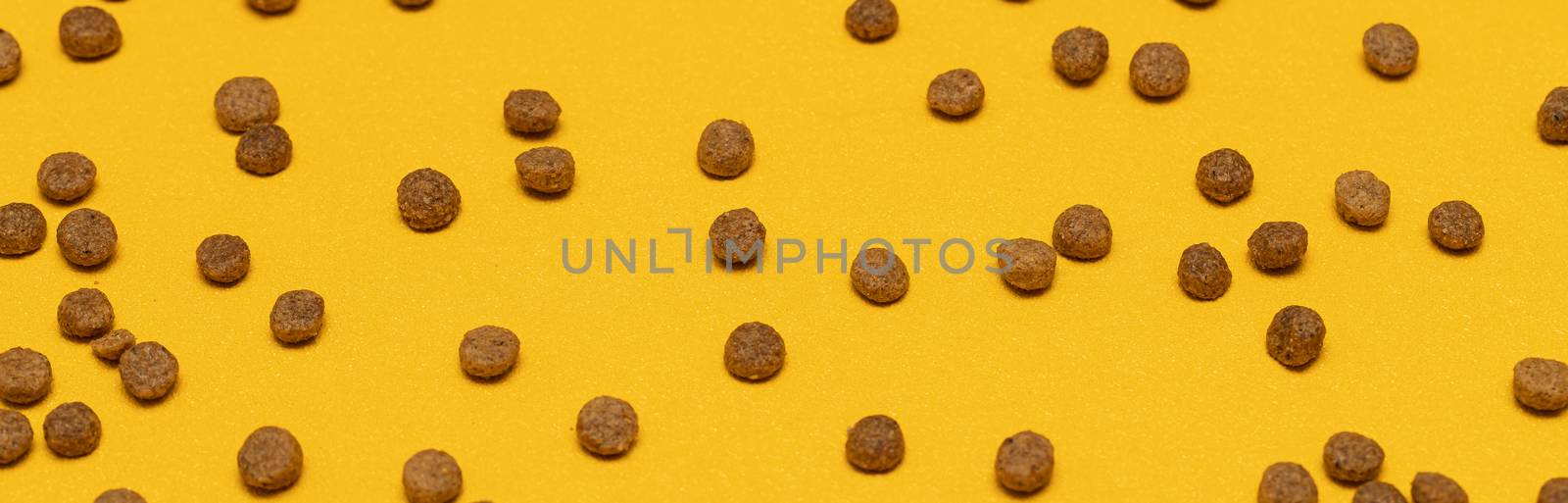 Balls of cat food on a yellow background. Background of pet food.