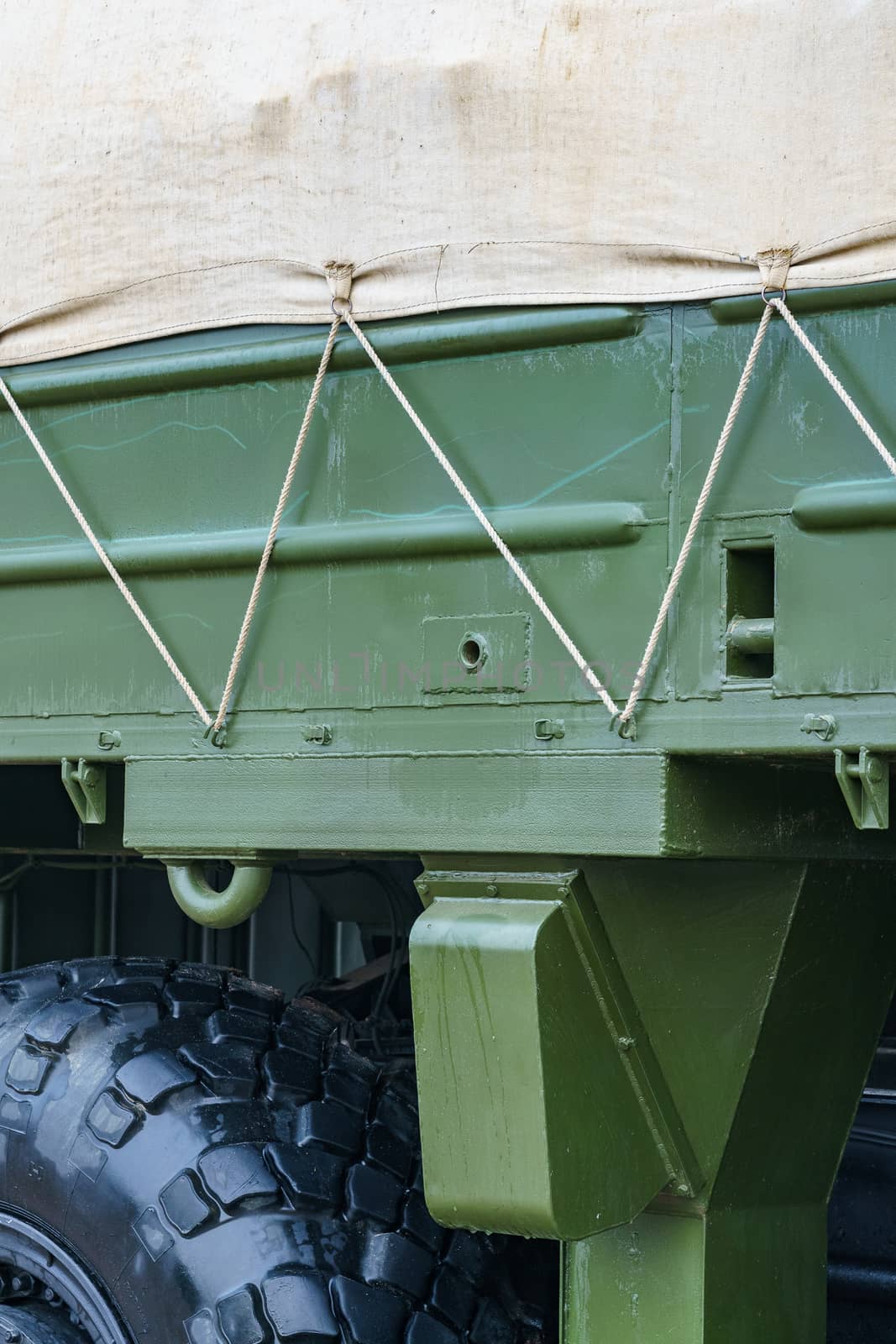 side of a dark green military truck with an awning  by VADIM