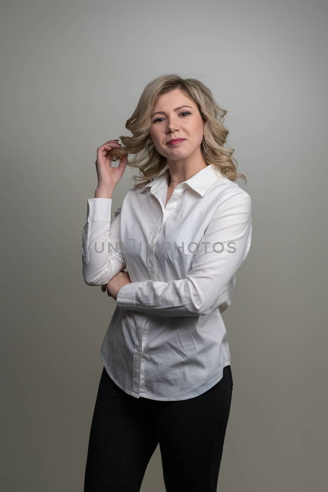 30 years old woman with blond hair in a white shirt posing in the studio