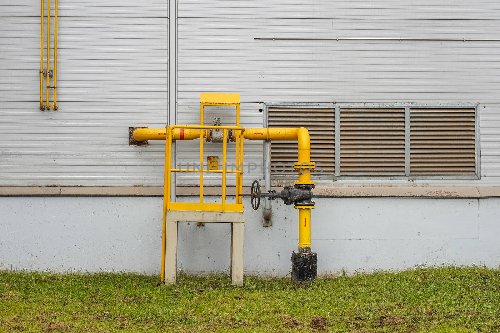 fire safety elements on the wall of an industrial building: stairs, fences, signs