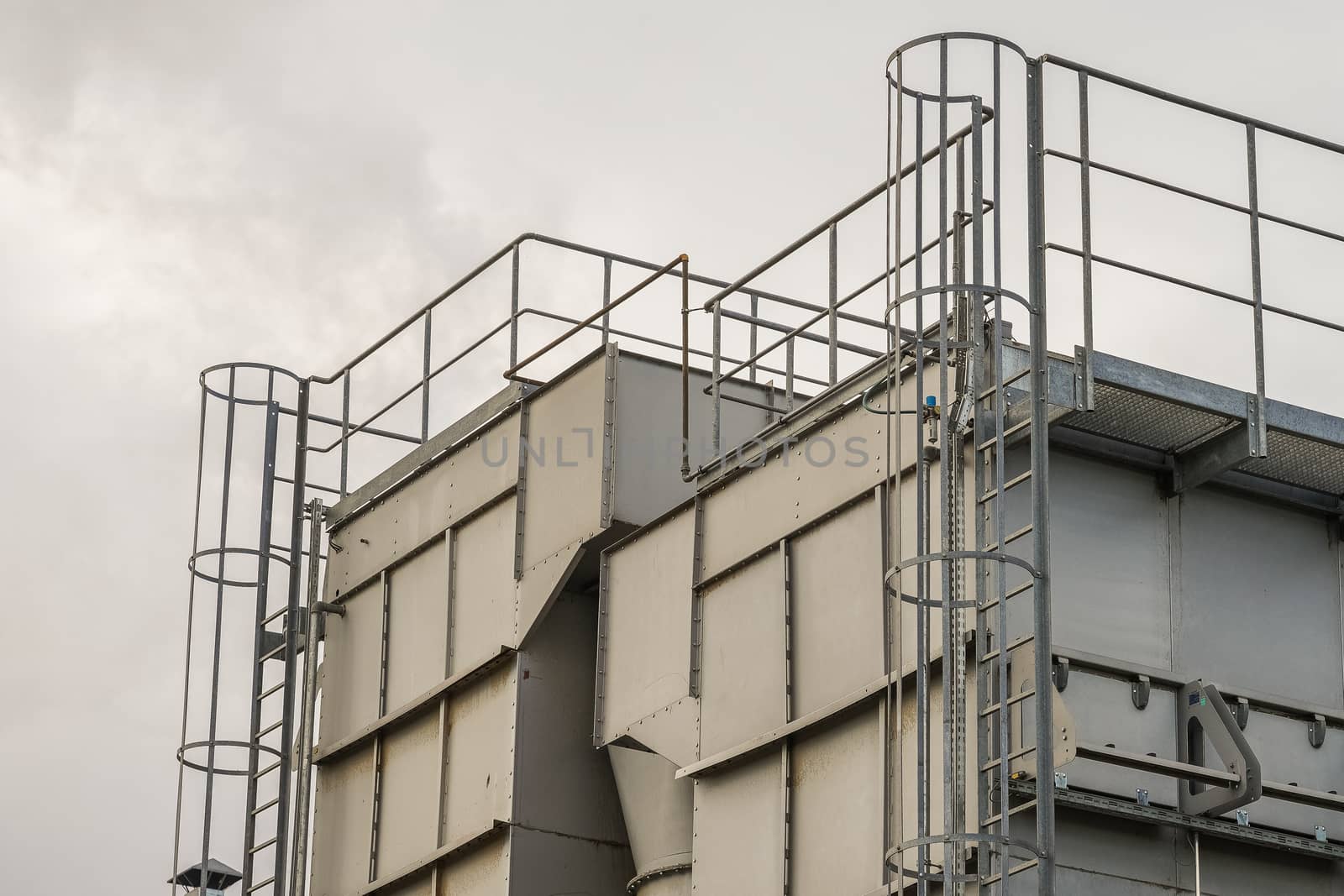 upper part of an industrial building with stairs, railings and other safety features