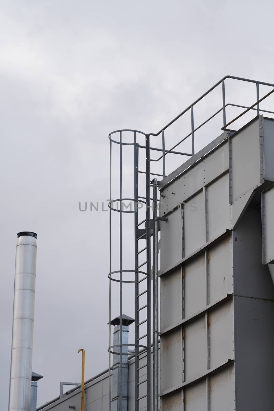 upper part of an industrial building with stairs, railings and other safety features