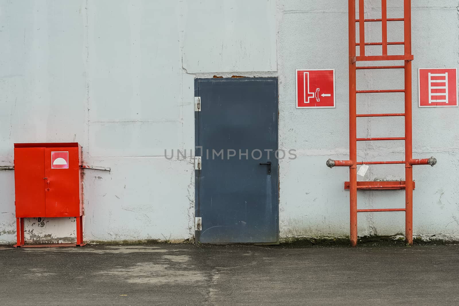 red fire escape leading to the roof of an industrial building