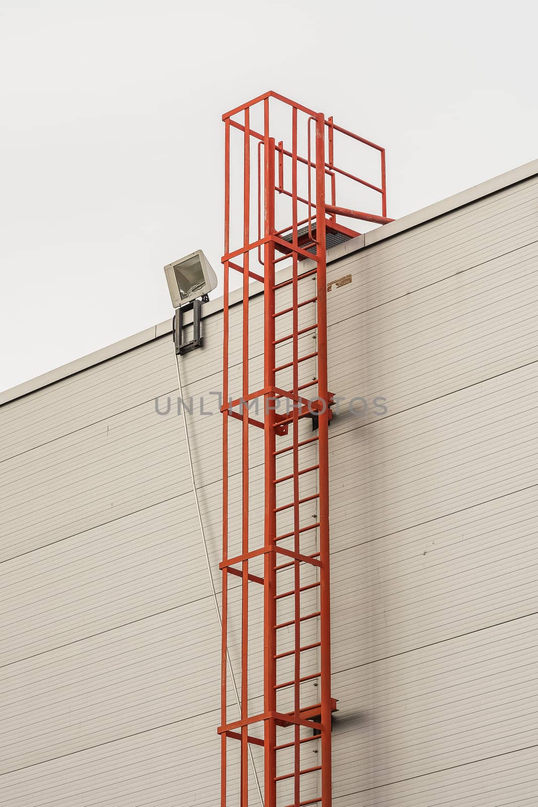 red fire escape leading to the roof of an industrial building