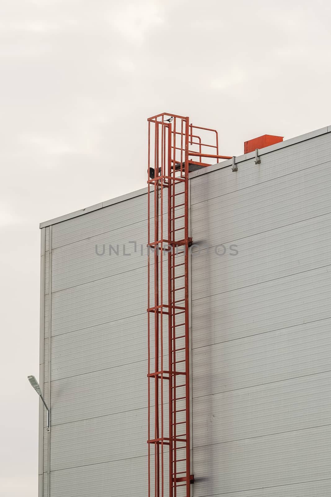 red fire escape leading to the roof of an industrial building