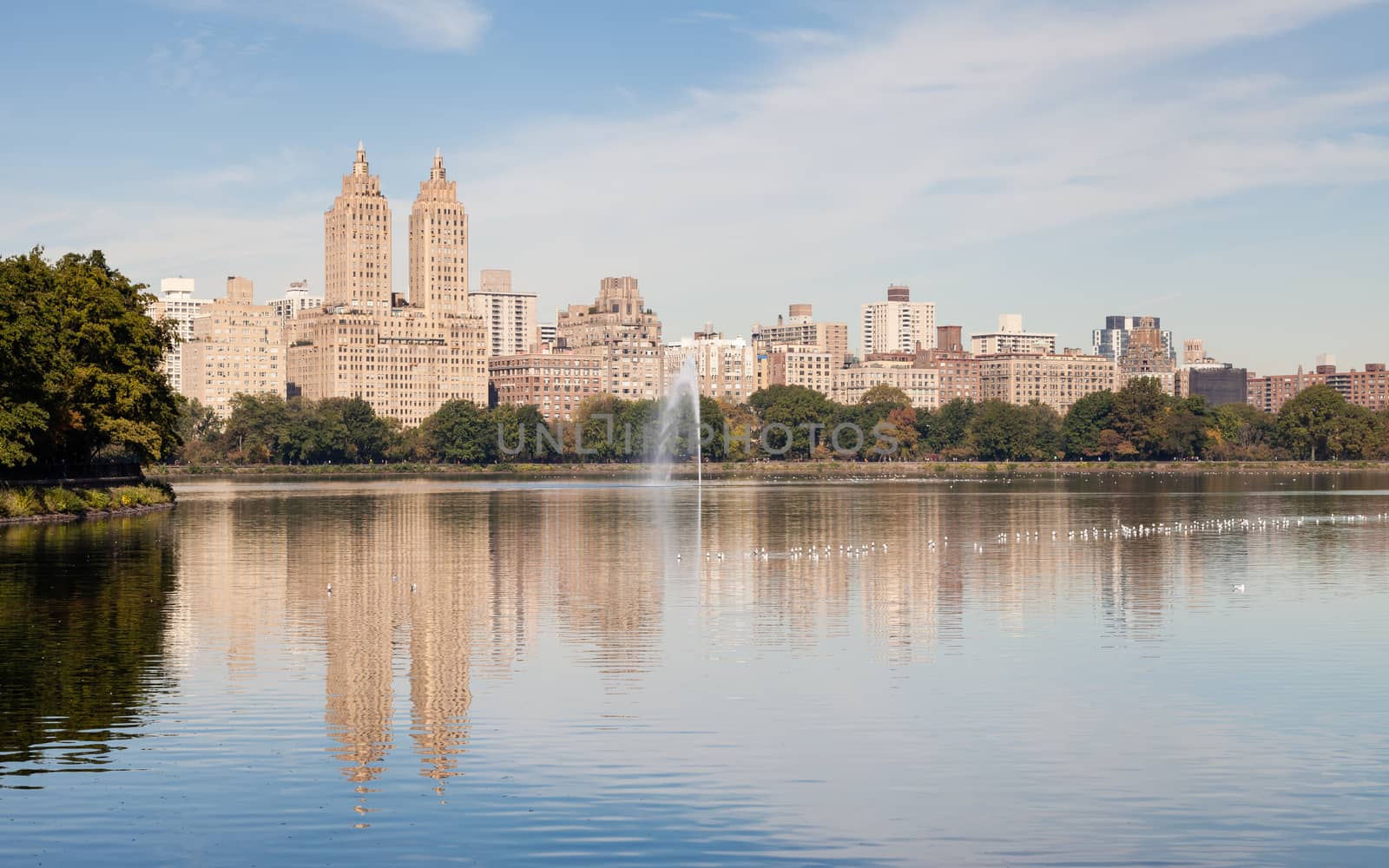 The view across the Jackie Onassis Reservoir in Central Park, New York City in the United States of America on a still autumn morning.