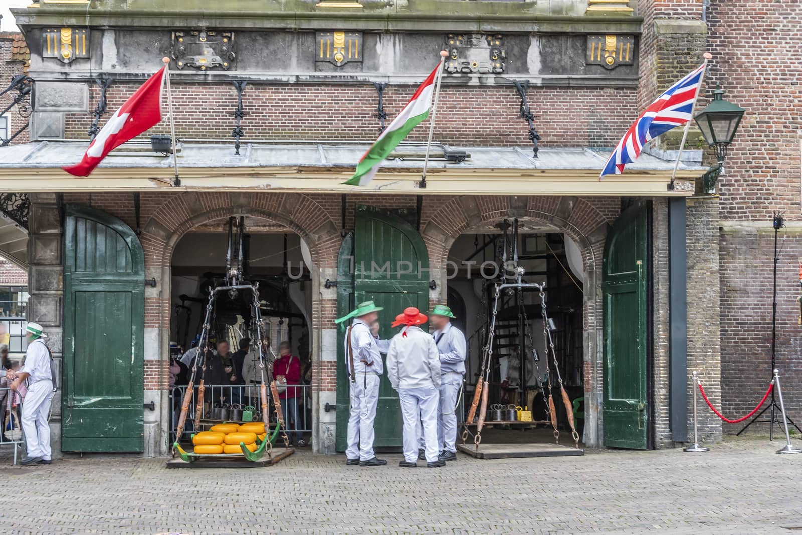 Old building of weights of the cheese market of Alkmaar and locals dressed in the old way. netherlands holland