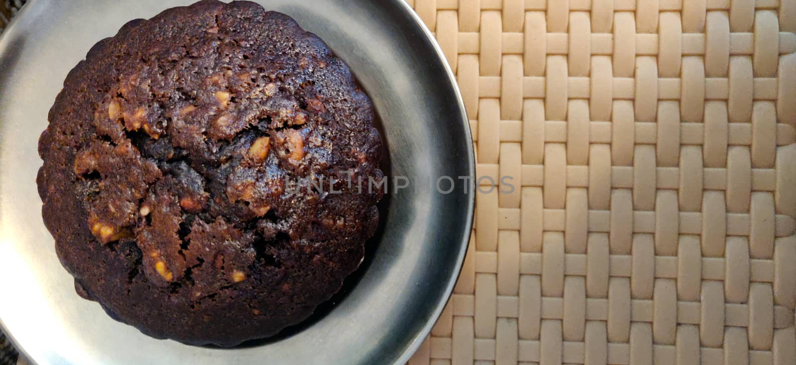 A close up of chocolate walnut muffin on a steel plate by mshivangi92