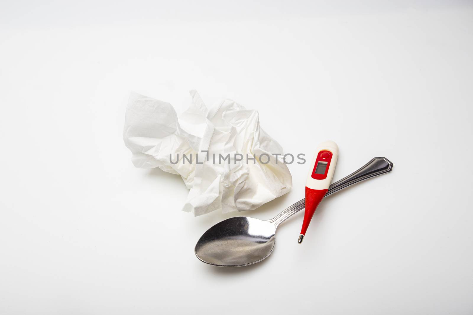 thermometer, spoon and crush tissue against a white background