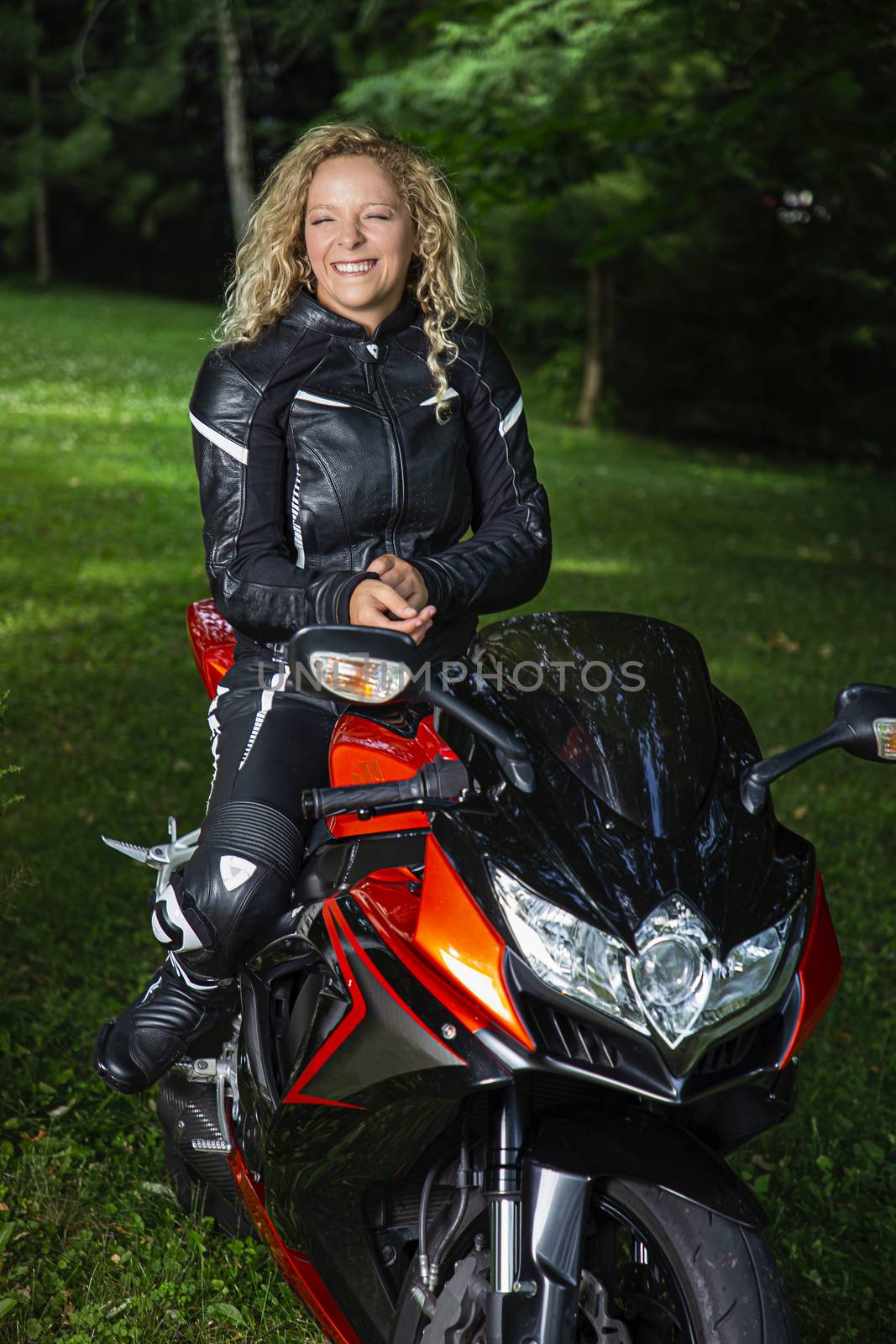 Young blond woman,  sitting a on sport motocycle