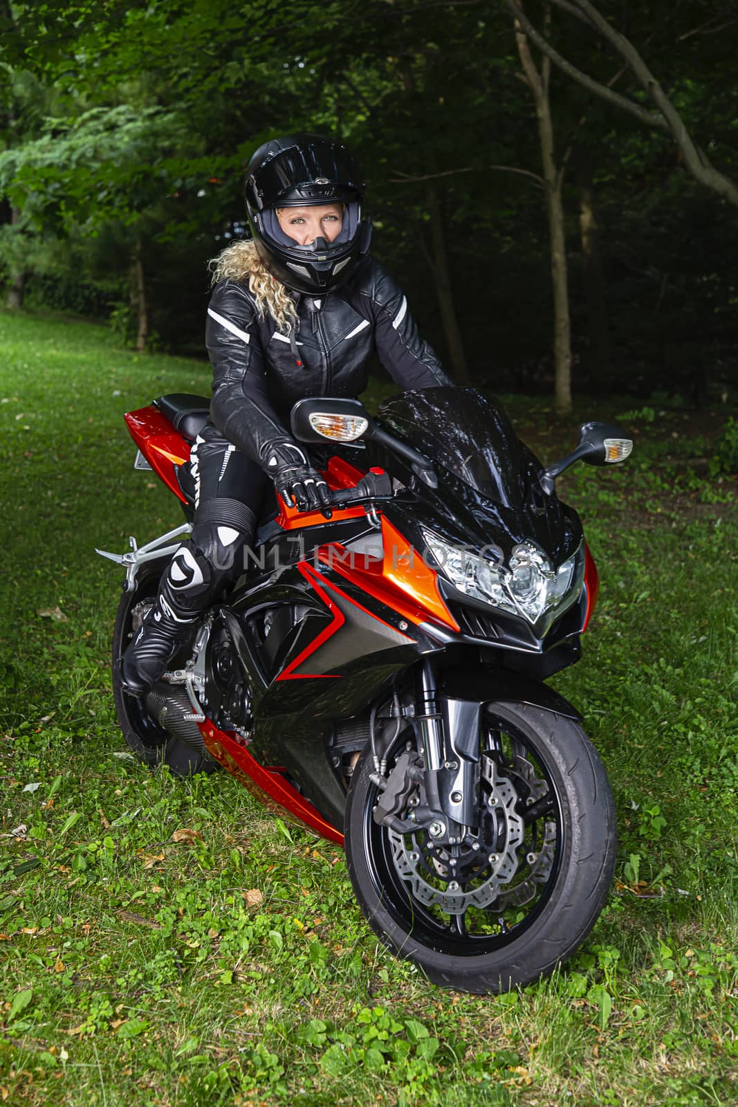 Woman wearing full protective gear sitting on a sport motocycle