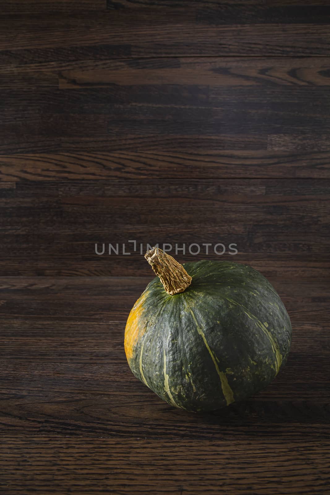 single Kabocha squash against a dark wood background