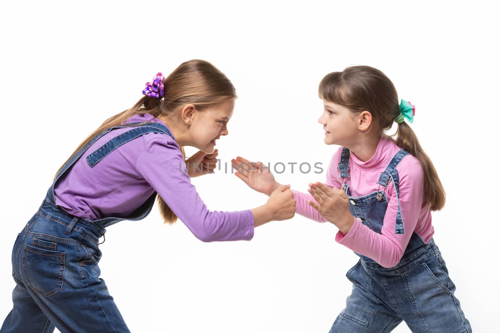 two girls quarrel and fight with each other on a white background