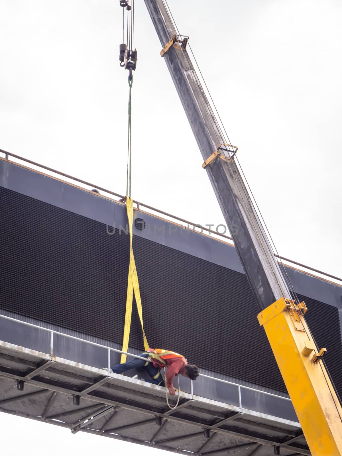 Construction site crane is lifting a led signboard Blank billboard on blue sky background for new advertisement