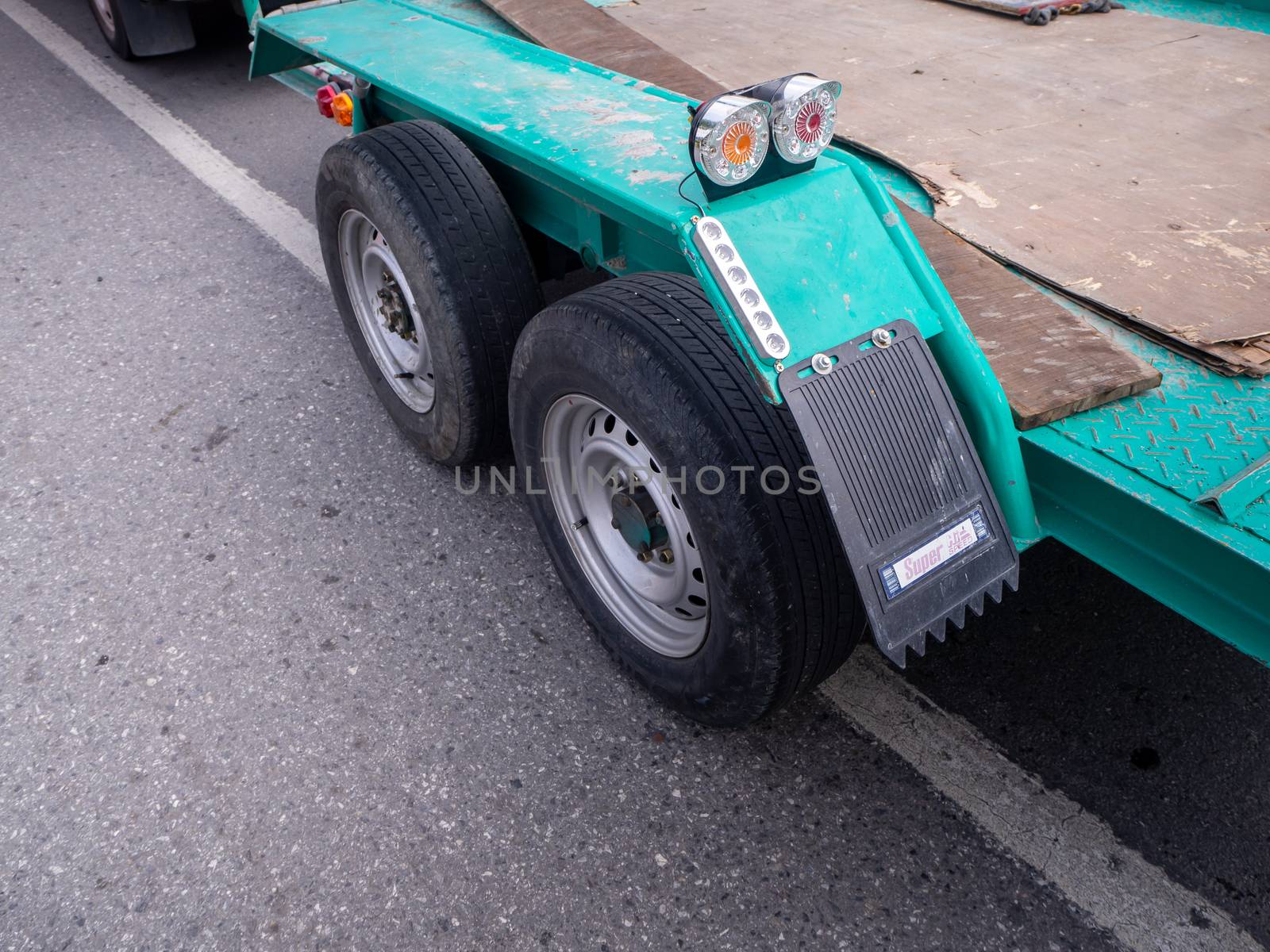 transporting small  cargo trailer for a car strapped on the road