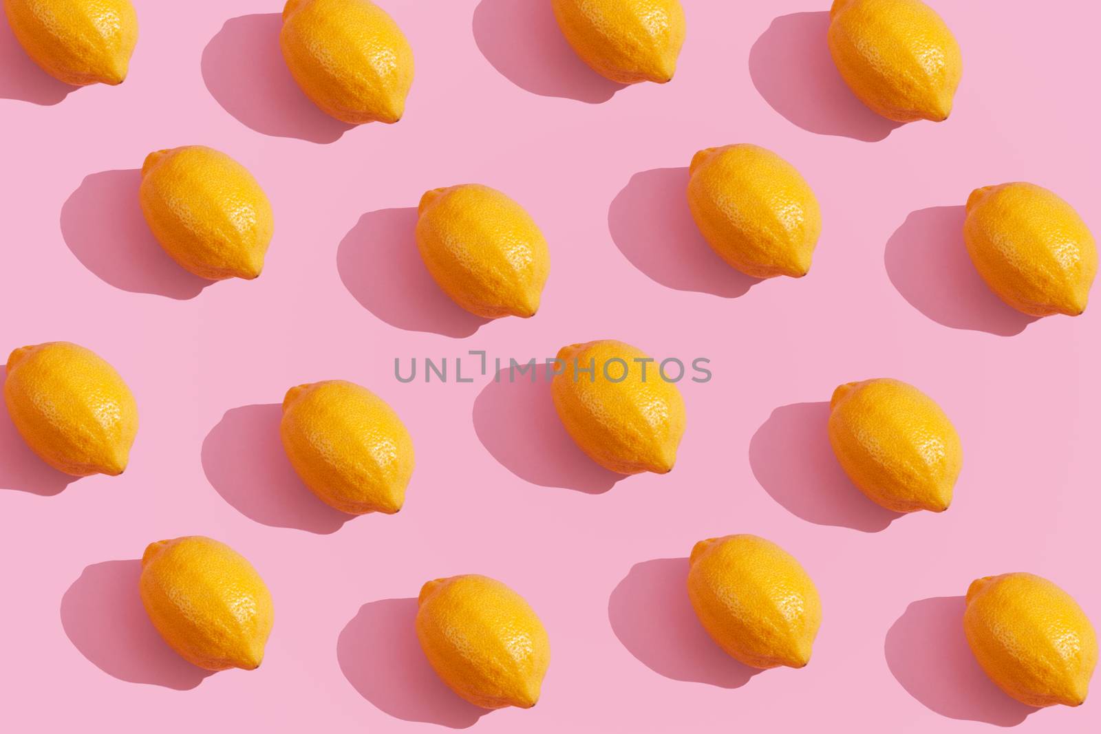 Trendy yellow lemon isometric pattern on pink background. Creative and modern minimal concept. Summer fresh flat lay food texture, copy space.