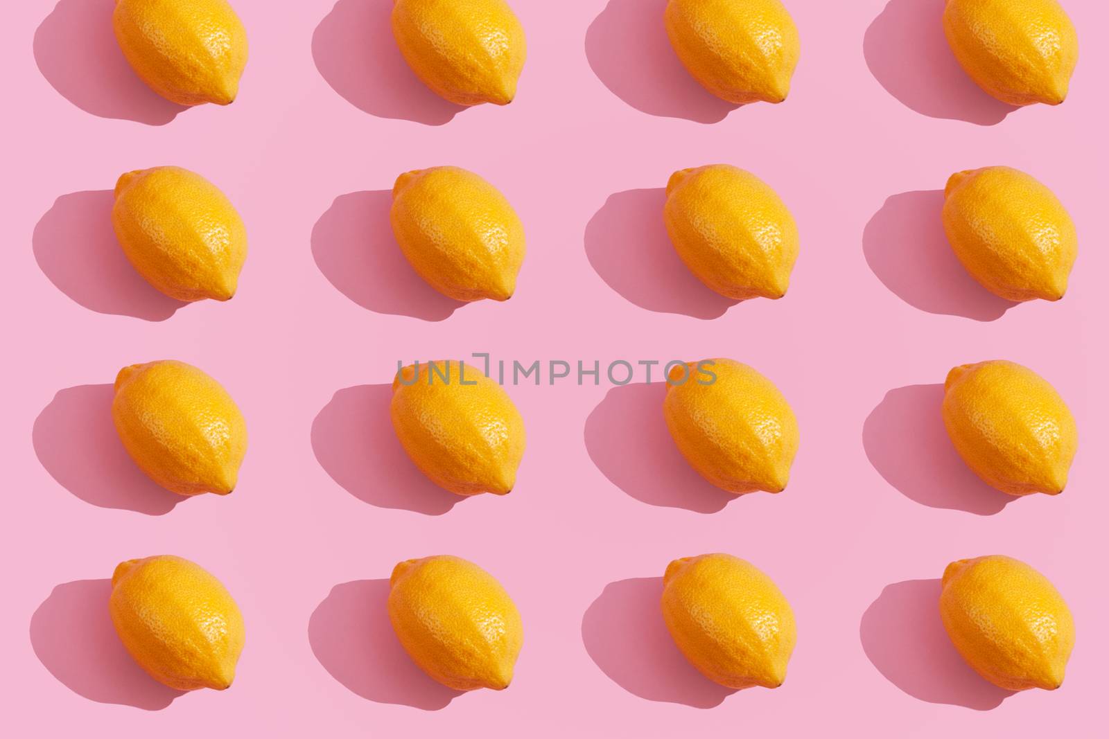 Trendy yellow lemon isometric pattern on pink background. Creative and modern minimal concept. Summer fresh flat lay food texture, copy space.