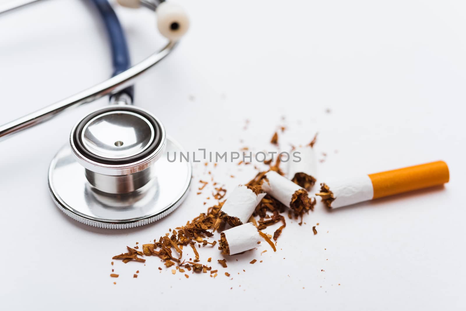 31 May of World No Tobacco Day, no smoking, close up of broken pile cigarette or tobacco and doctor stethoscope on white background with copy space, and Warning lung health concept