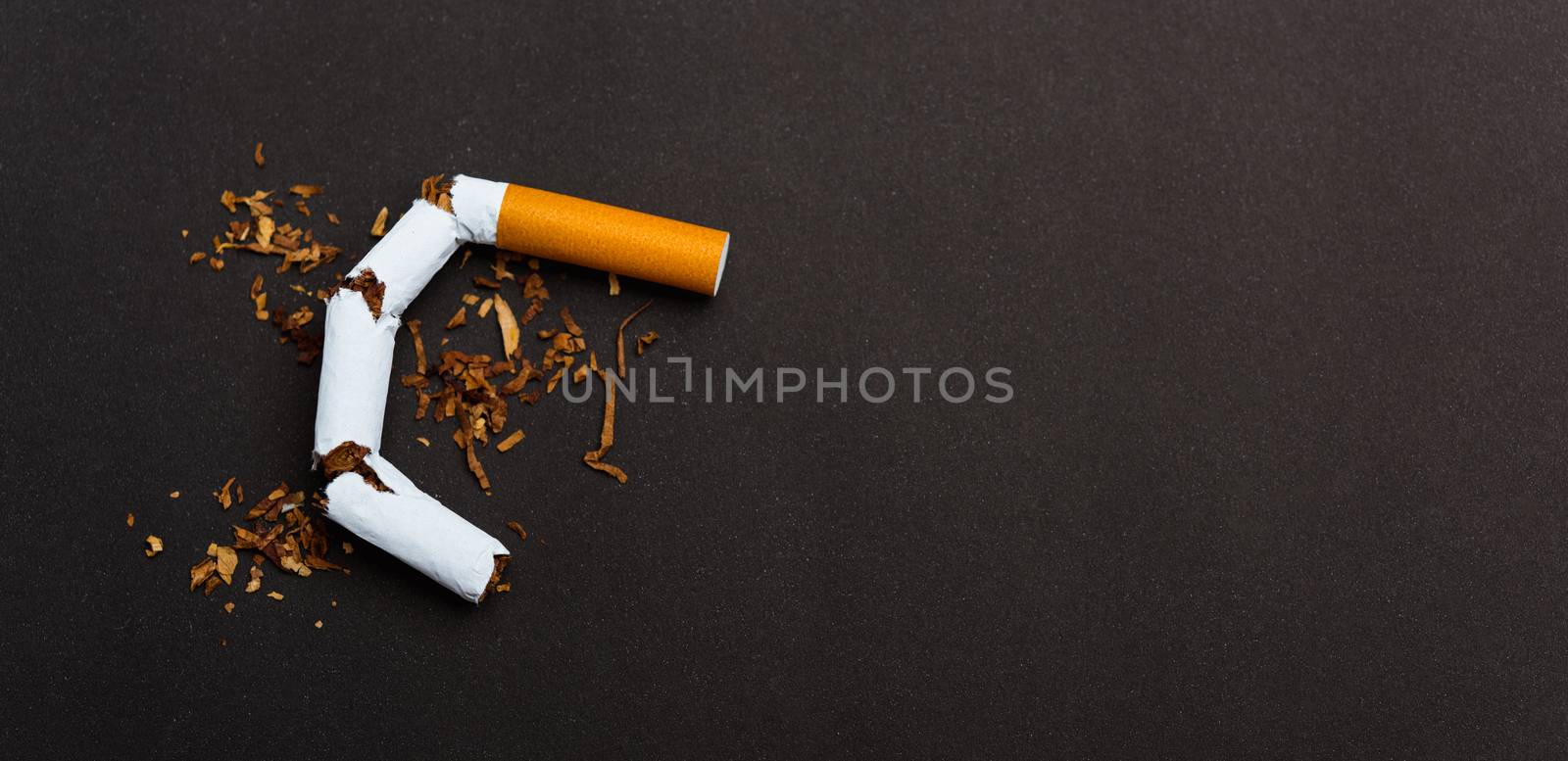 broken pile cigarette or tobacco on black background by Sorapop